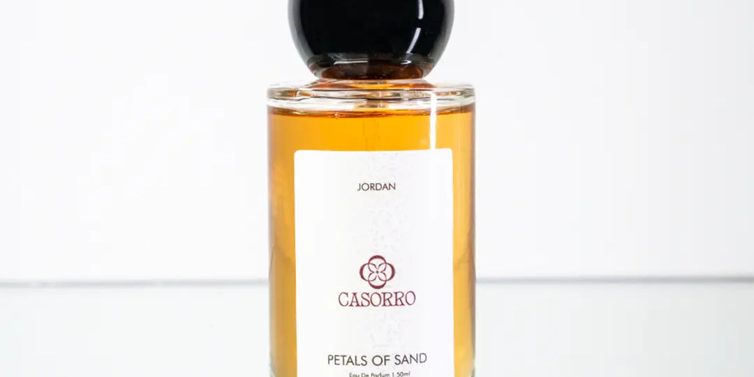 Perfume bottle labeled 'Petals of Sand' by CASORRO on a white background