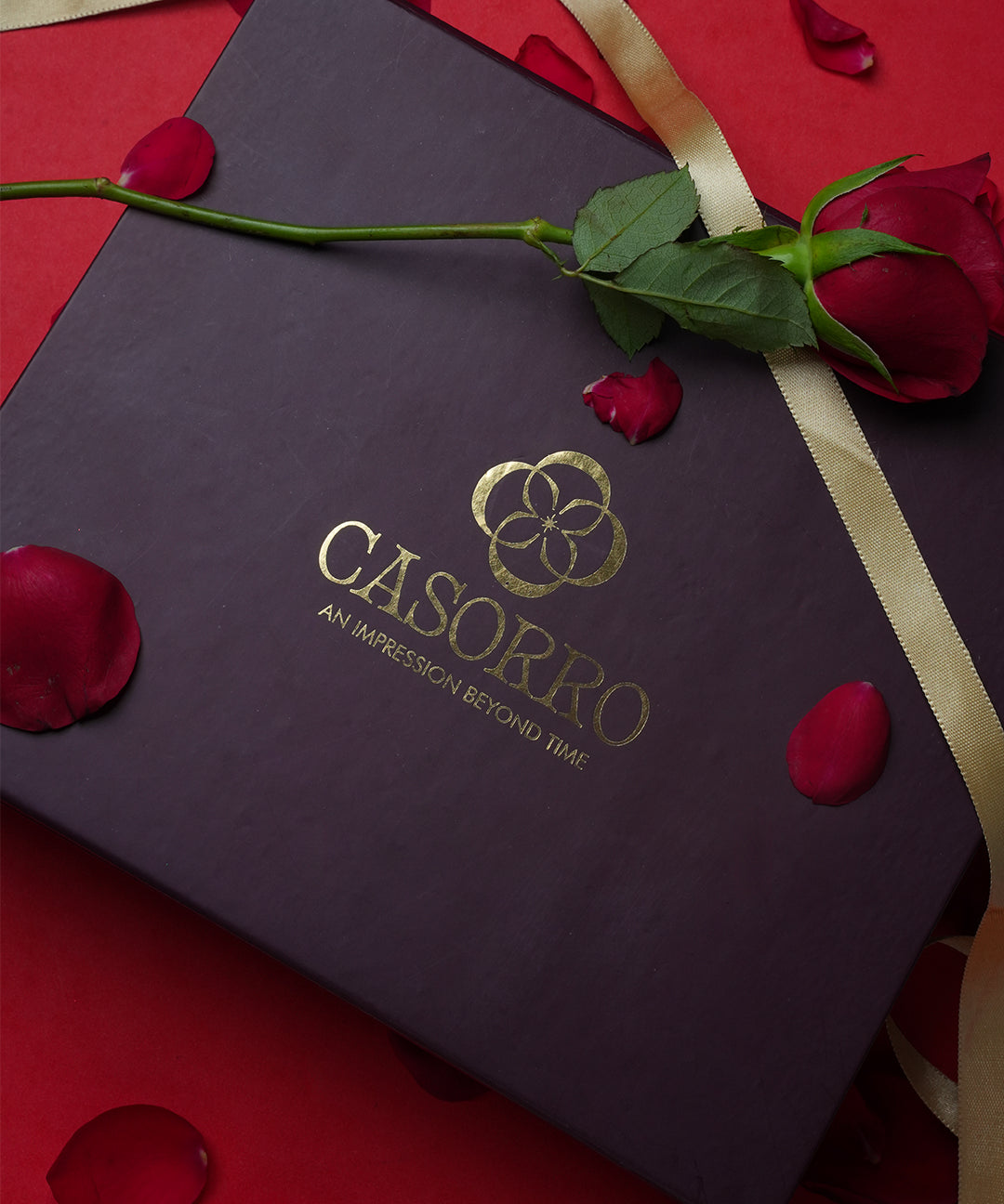 Dark purple box with gold 'Casorpo' logo on a red background with rose petals