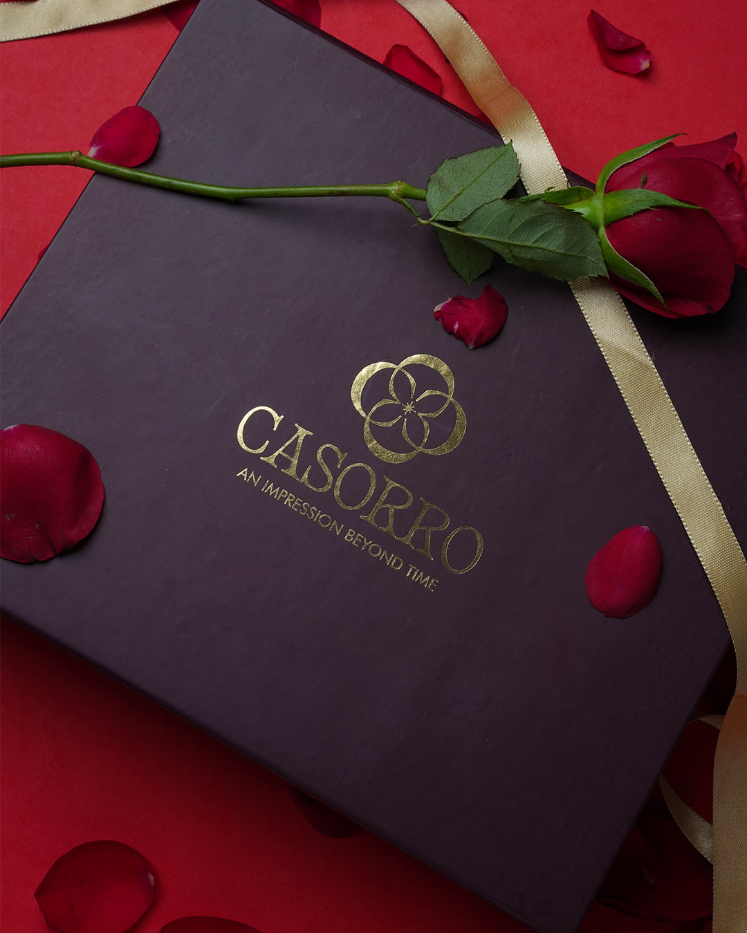 Dark purple box with gold 'Casorpo' logo on a red background with rose petals