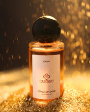 CASORRO- Petals of Sand perfume bottle on a glittery surface with a blurred background